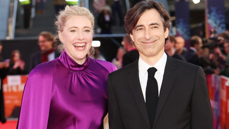 Greta Gerwig and Noah Baumbach smiling on a red carpet