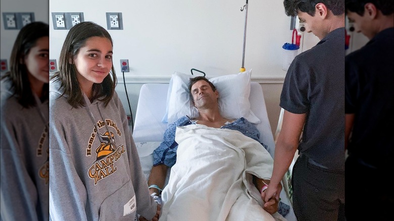 Cameron Mathison's kids holding his hands while he's in the hospital