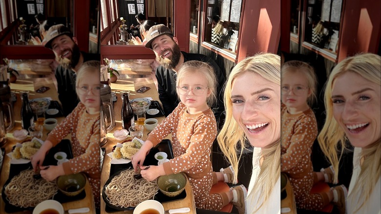 Jasmine and Brett Roth sitting at a table with their daughter Hazel