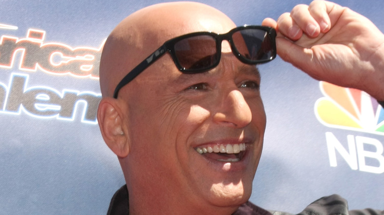 Howie Mandel raising a pair of sunglasses from his eyes