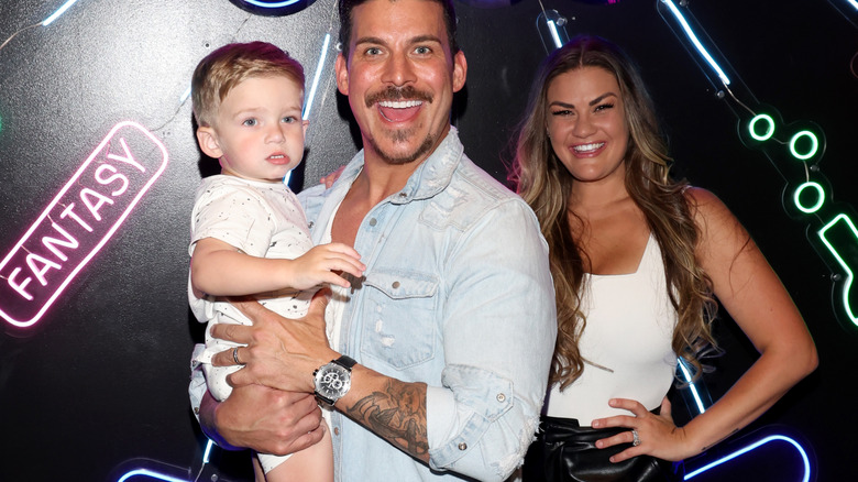 Jax Taylor holding his son with Brittany Cartwright while she smiles