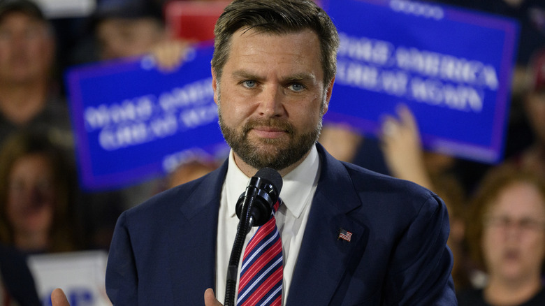 JD Vance looking right into the camera with raised hands