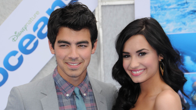 Joe Jonas and Demi Lovato smiling posing on red carpet