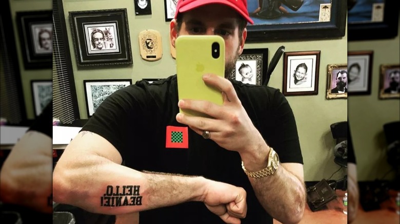 Jonah Hill showing a tattoo that reads "Hello, Beanie!" on his forearm