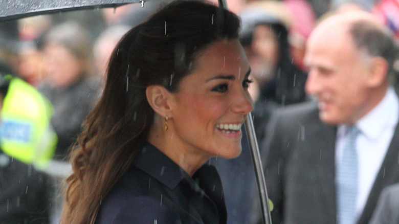 Princess Catherine smiling under an umbrella