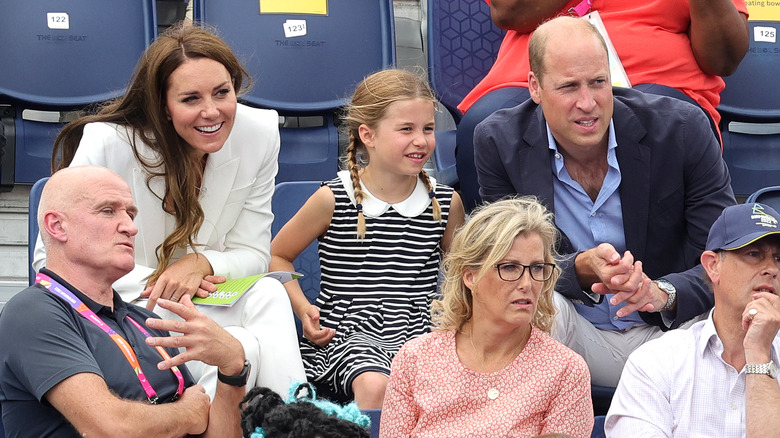 Princess Charlotte sitting in bleachers with parents