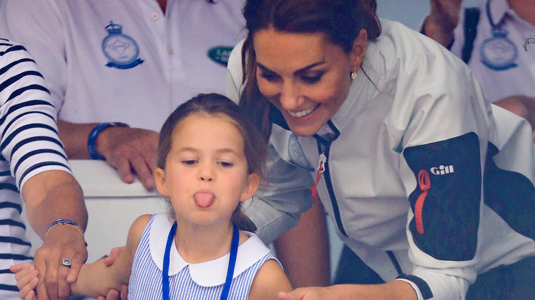 Kate Middleton with Charlotte sticking out her tongue