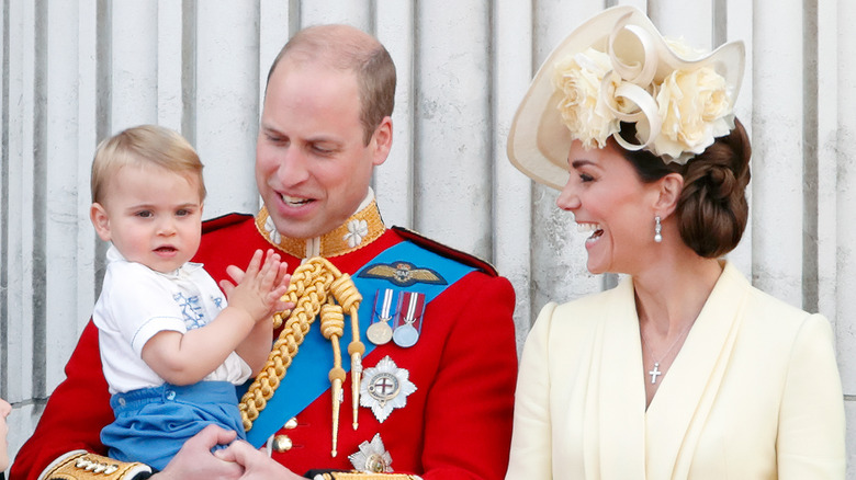 Prince William holding Prince Louis with Princess Catherine