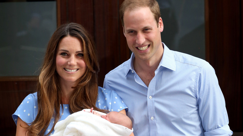 Kate Middleton and Prince William holding baby