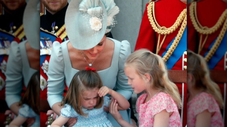 Princess Catherine picking up Princess Charlotte