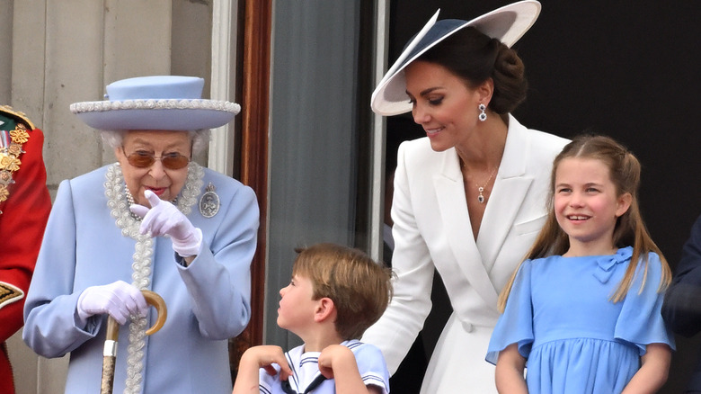 The queen chatting with Prince Louis on balcony