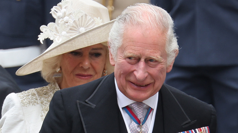 King Charles III walking in front of Queen Camilla 