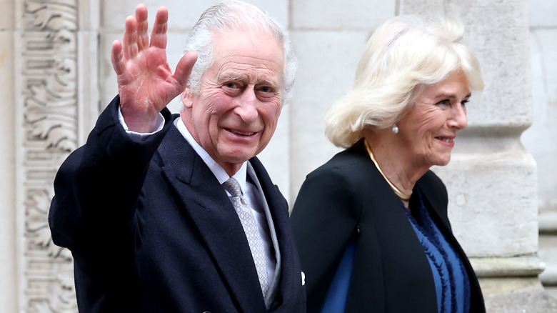 King Charles III waving alongside Camilla