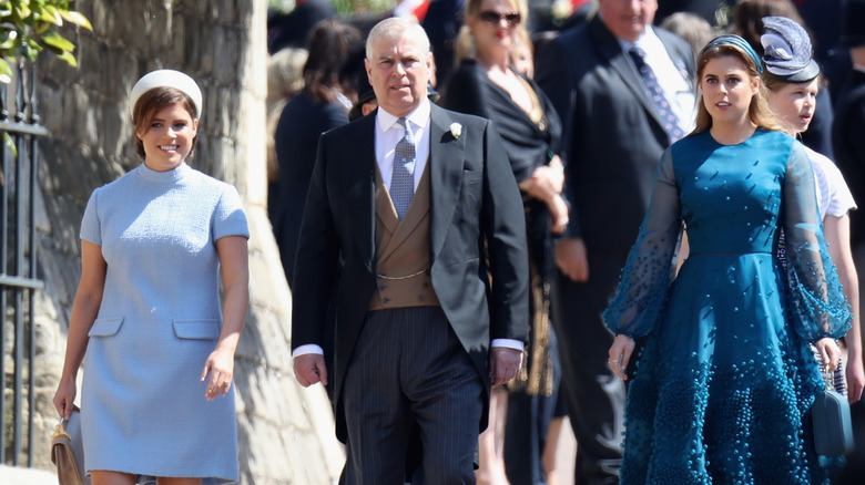 Prince Andrew walking with Princesses Beatrice and Eugenie