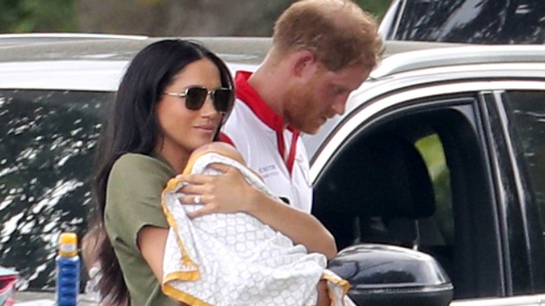 Prince Harry with Meghan holding baby 