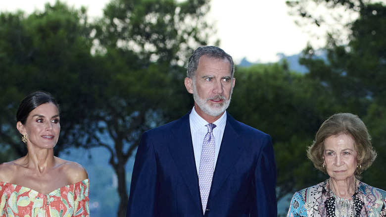 Queen Letizia, King Felipe and Queen Sofia walking together 