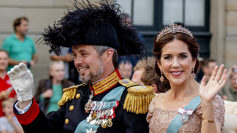 King Frederik X and Queen Mary waving in carriage