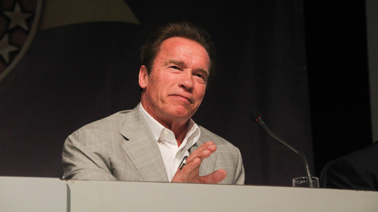 Arnold Schwarzenegger speaking behind desk