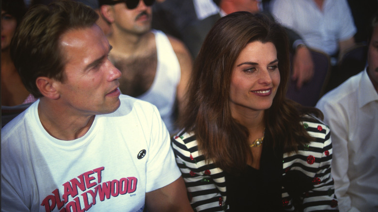 Arnold Schwarzenegger and Maria Shriver seated in event audience