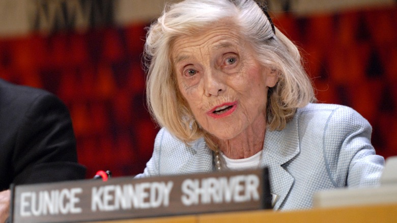 Eunice Kennedy Shriver sitting behind a nameplate