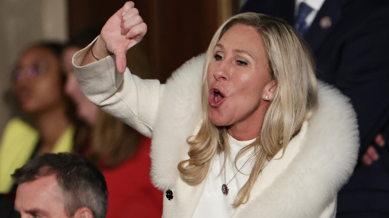 Marjorie Taylor Greene shouting while showing a thumbs down