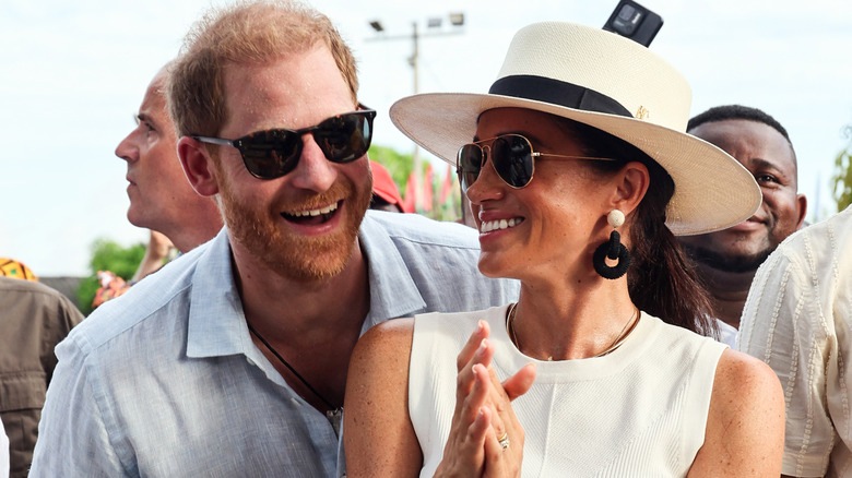 harry and meghan smiling on trip abroad