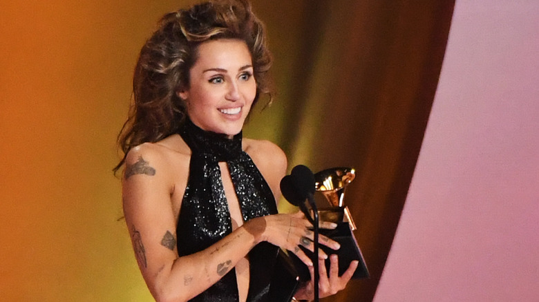 Miley Cyrus holding Grammy on stage