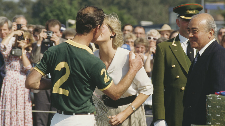 King Charles and Princess Diana kissing next to Mohamed Al-Fayed