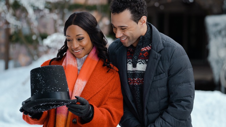 Monique Coleman and Corbin Bleu smiling at a hat in a still from 'A Christmas Dance Reunion'
