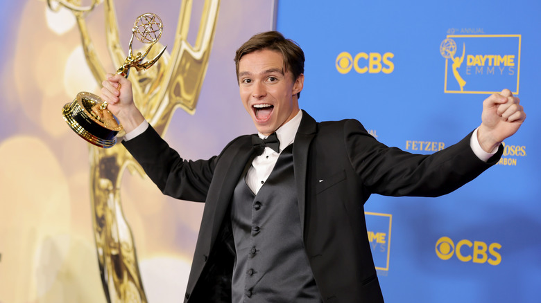 Nicholas Alexander Chavez smiling while holding his daytime emmy in the air