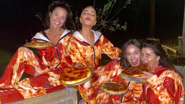 Lisa McCaffrey and Olivia Culpo wearing pizza onesies 