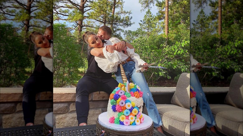 Olivia Culpo and Christian McCaffrey posing with unicorn cake 