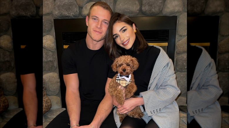 Oliva Culpo and Christian McCaffrey holding dog 