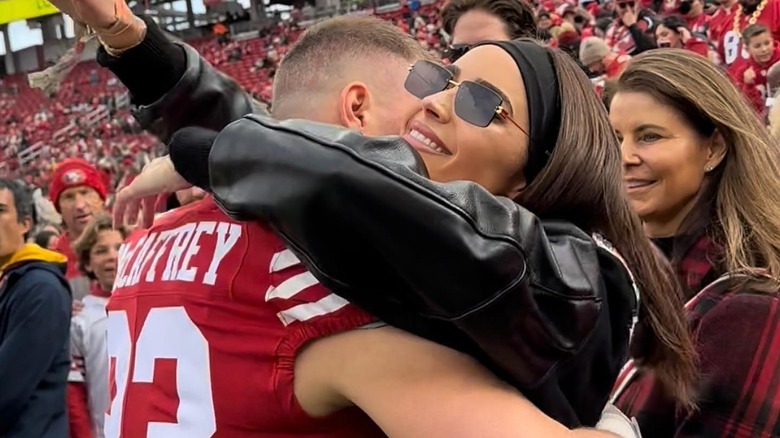 Olivia Culpo hugging Christian McCaffrey at football game