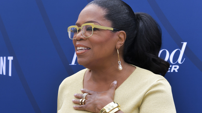 Oprah Winfrey holding her hand to her chest