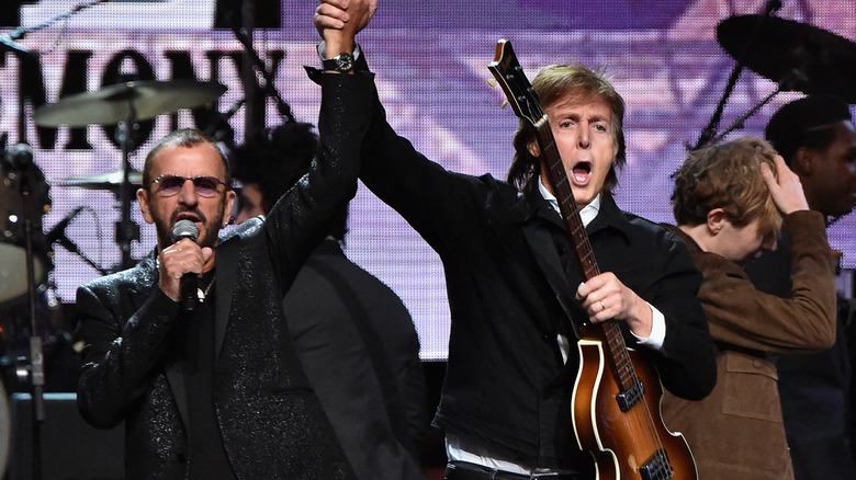 Ringo Starr and Paul McCartney perform on stage.