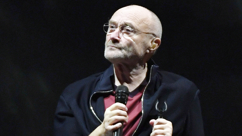 Phil Collins performs on stage.