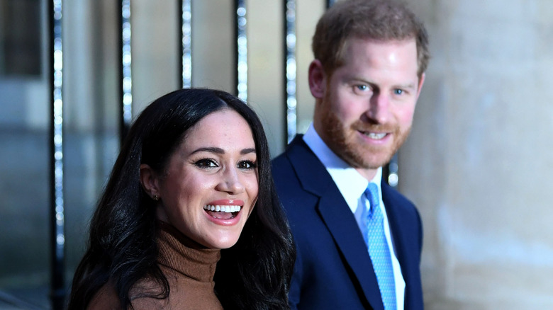 Prince Harry and Meghan Markle smiling and walking together