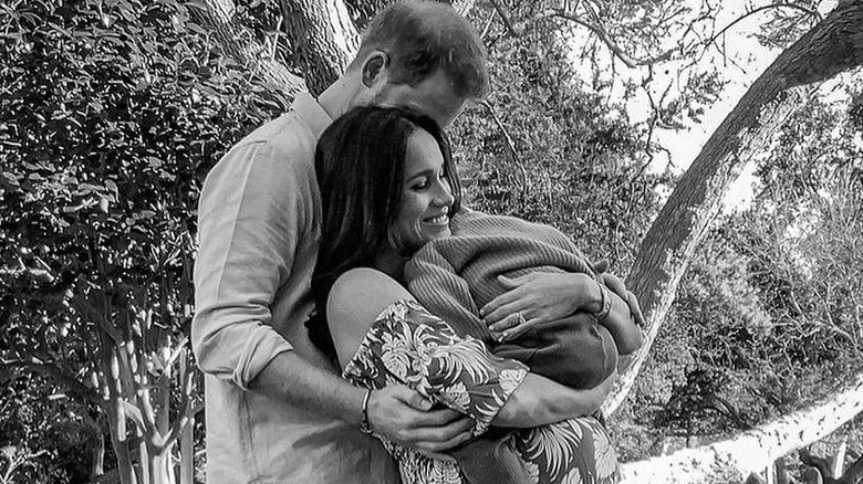 Prince Harry and Meghan Markle holding baby