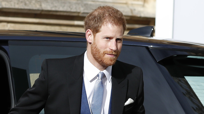 Prince Harry smirking getting out of car