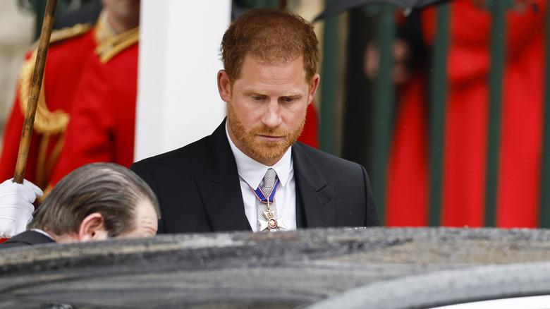 Prince Harry approaching car in rain