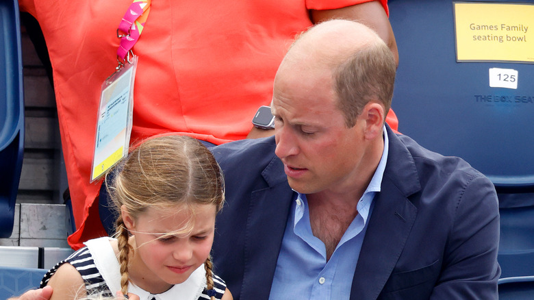 Prince William with an arm around Princess Charlotte