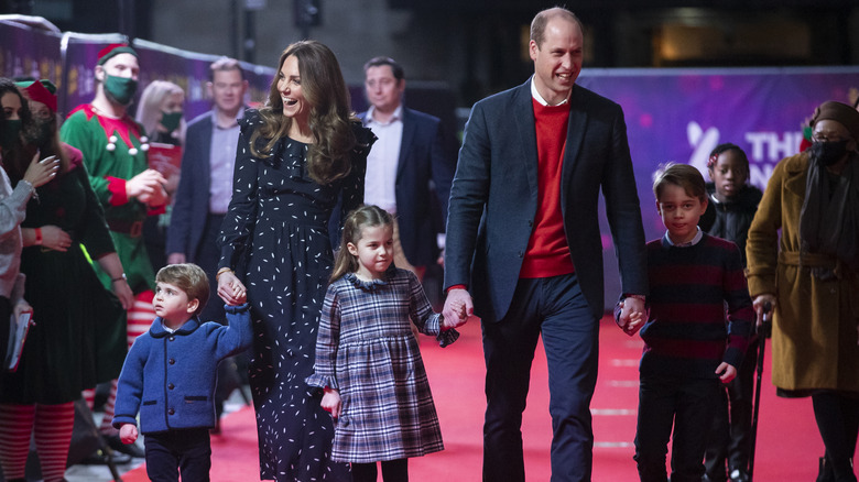 Prince William holding Princess Charlotte's hand