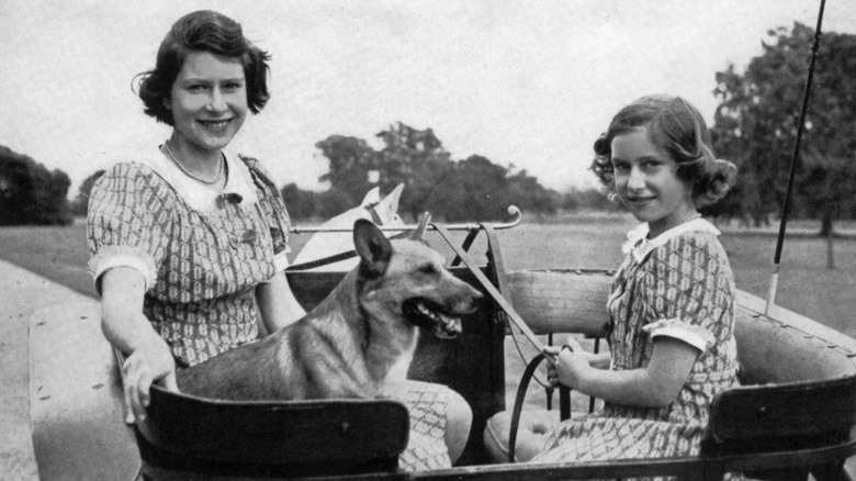 Young Princess Margaret and Queen Elizabeth sitting with a dog