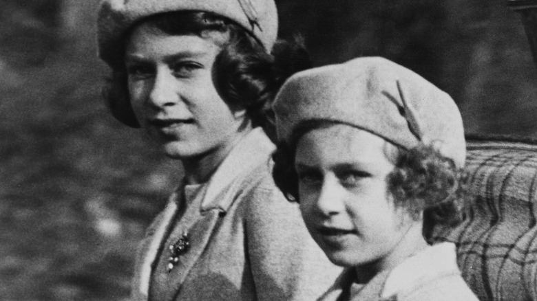 Young Queen Elizabeth sitting next to Princess Margaret