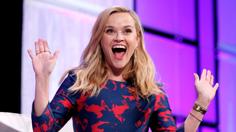 Reese Witherspoon laughing hands up