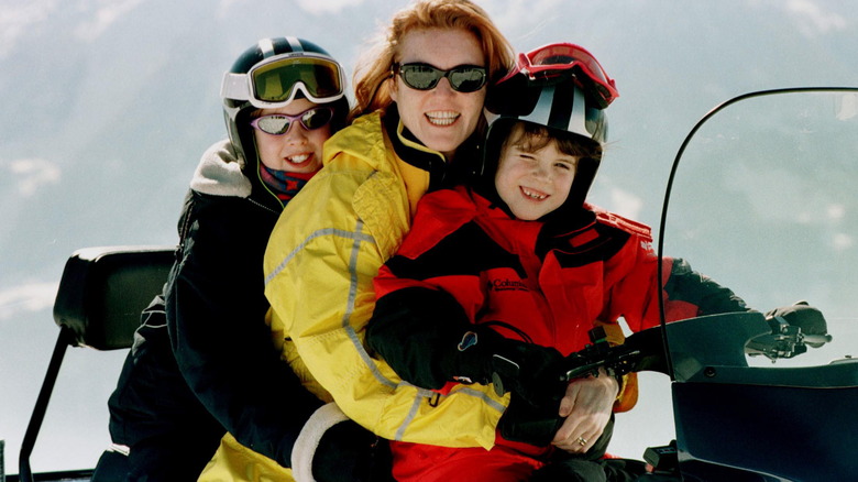 Sarah and her young daughters on snowmobile, smiling