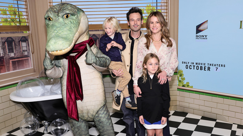 Scoot McNairy, his son and daughter, and Sosie Bacon posing with a crocodile mascot