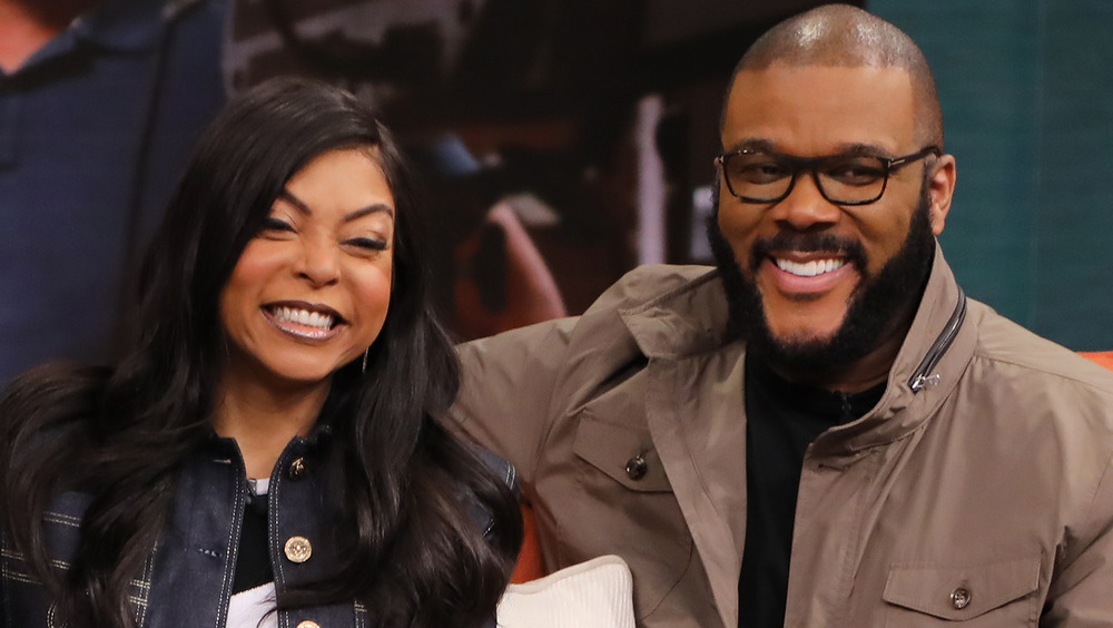 Taraji P. Henson and Tyler Perry smile on a couch