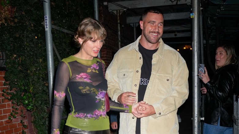 Travis Kelce and Taylor Swift holding hands